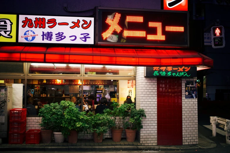 a large clock above a restaurant that has neon lights