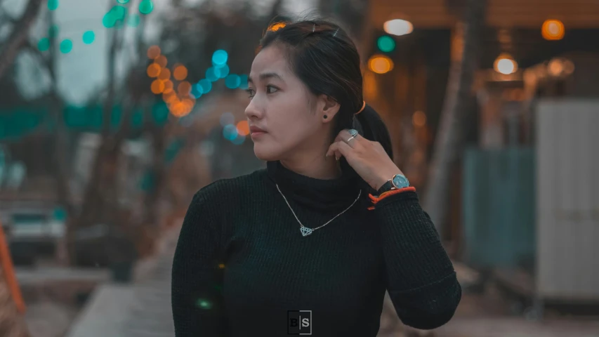 a woman with black hair and a green shirt is talking on a phone