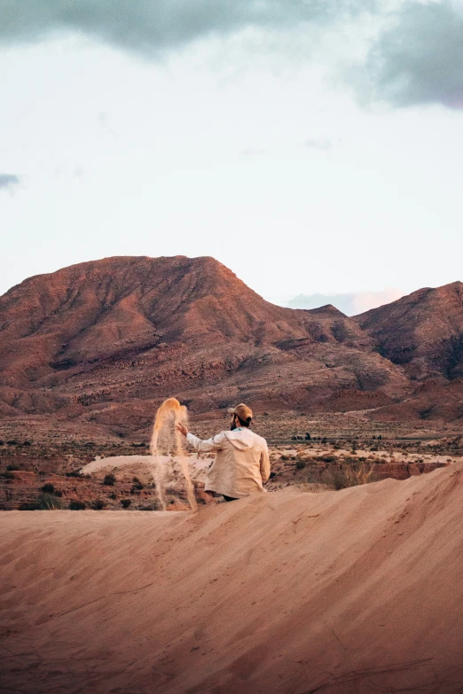 a woman walking in the desert with her back turned towards the pographer