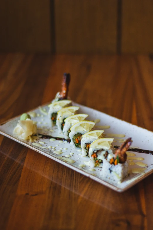 a piece of sushi sits on a plate with a wooden spoon