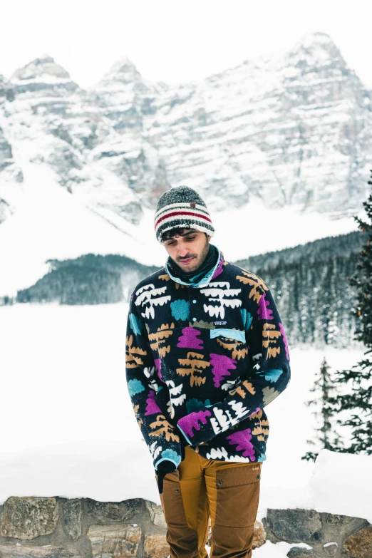 a man standing on a snow covered mountain posing