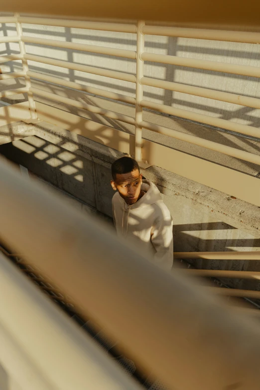 a boy stands on a railing near stairs