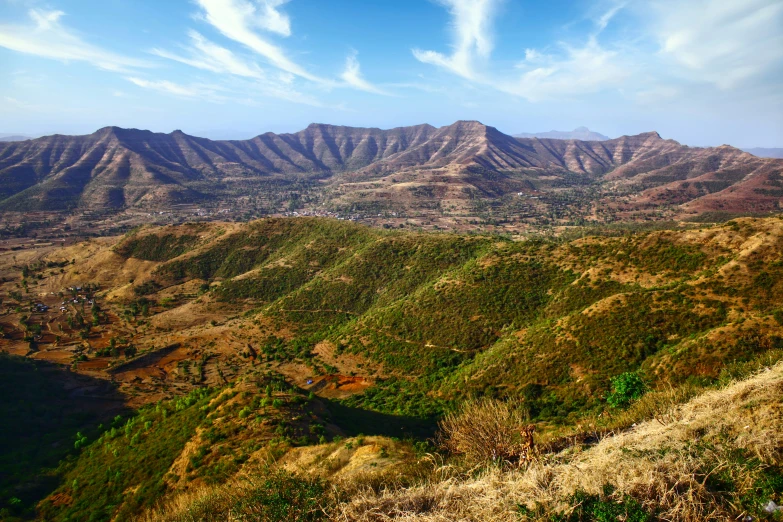 a view of mountains and plains from the top of a hill