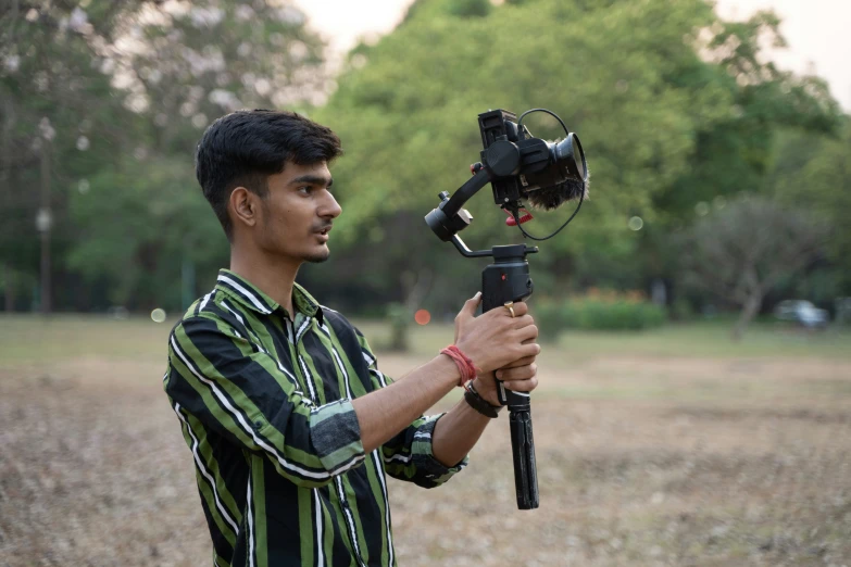 a man holding a camera and an in hand tripod