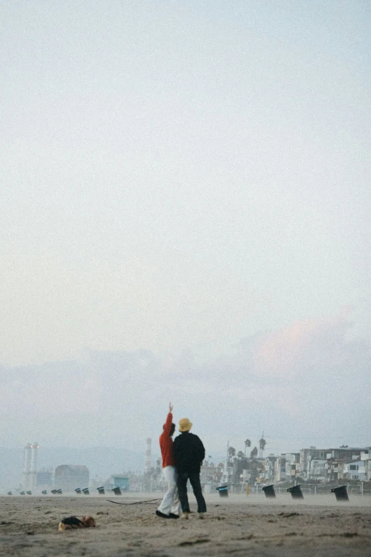 two people holding hands flying a kite on the beach