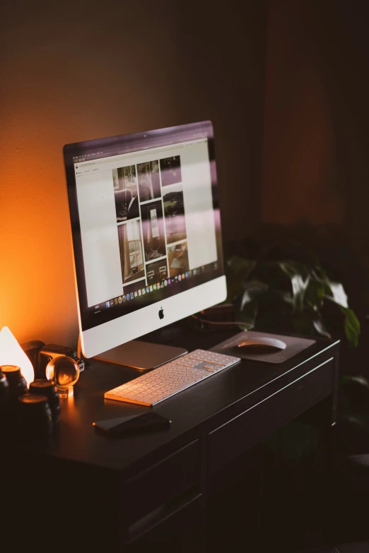 a computer monitor sitting next to a lamp on a desk