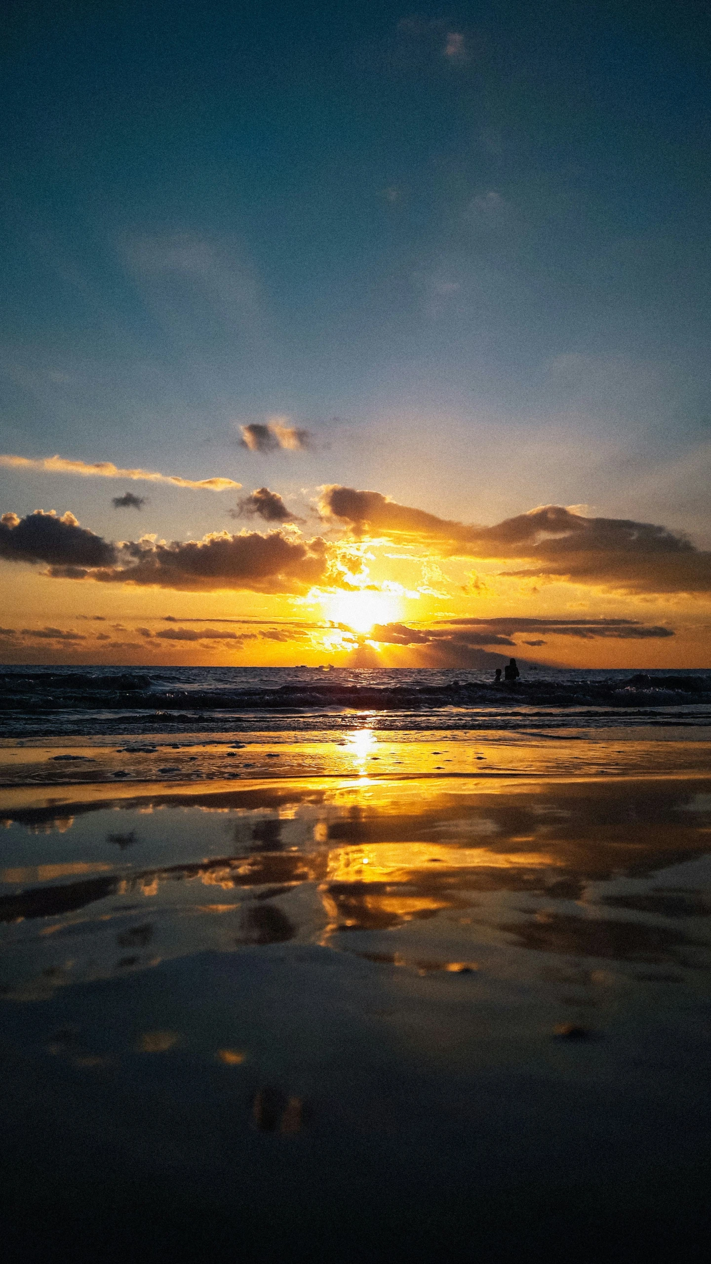 the sun sets over a body of water at the beach