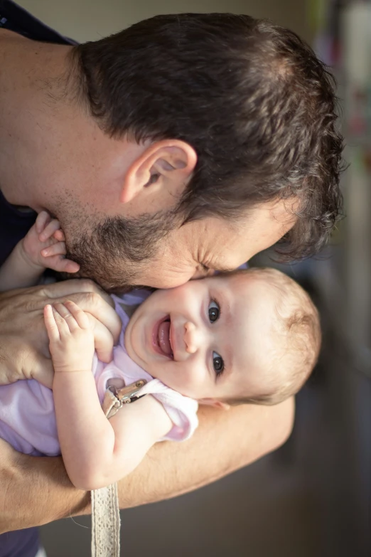 the man is holding the baby in his arms