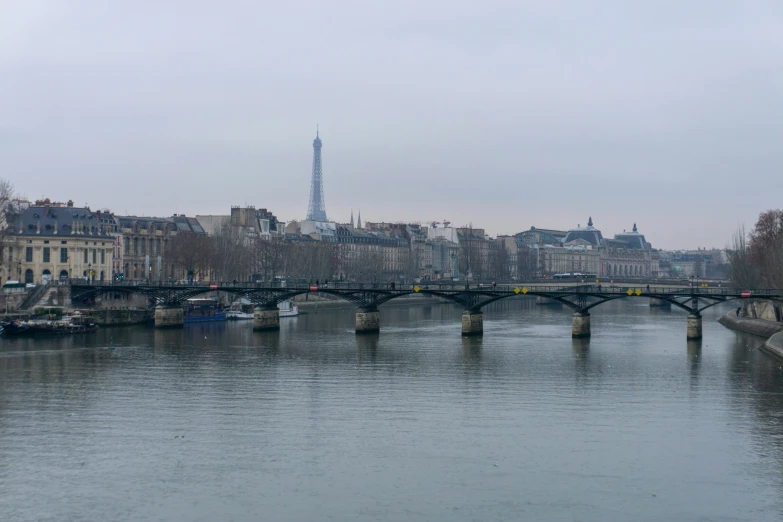 a bridge that has boats going across it and a tower in the background