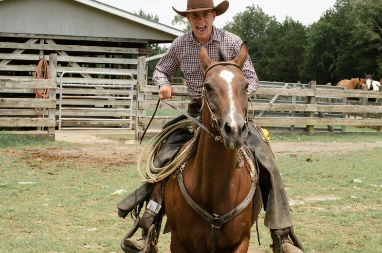 a cowboy on a horse smiles into the camera