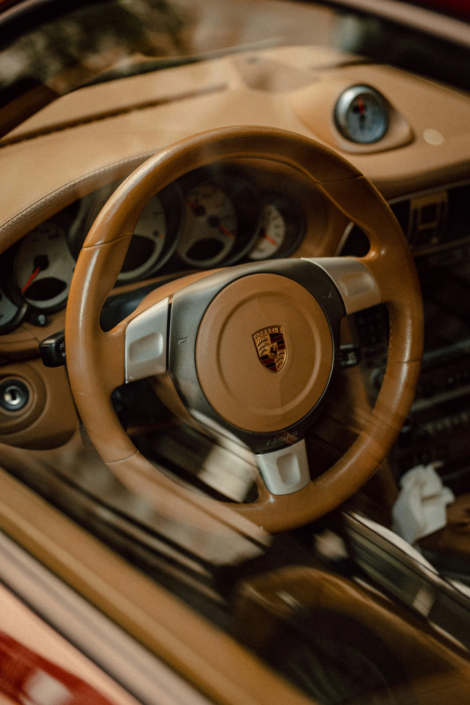 dashboard s of a brown luxury car with beige leather steering wheel