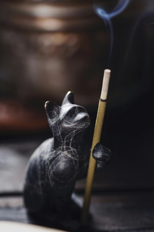 a small black smoke bunny sitting next to a cigarette holder