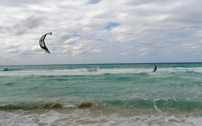 a man kiteboarding over the ocean while holding onto a rope