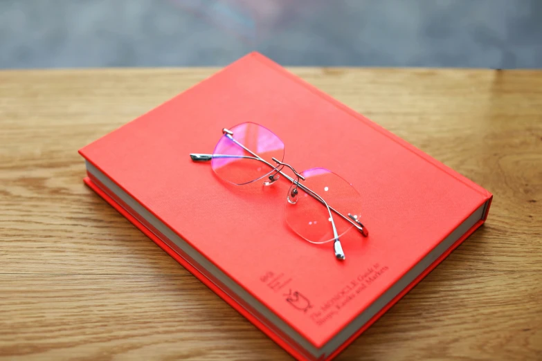 an orange book with some glasses on top of it