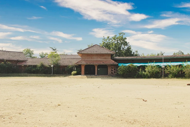 an empty yard has a brown clock tower in the center