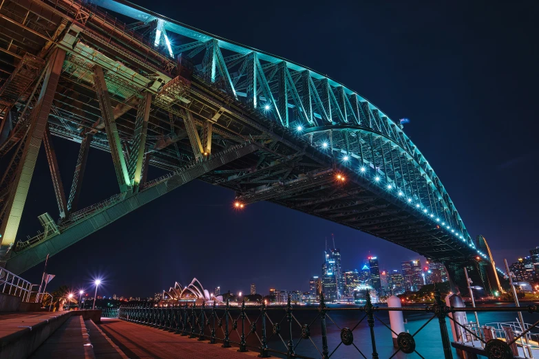 a large bridge is seen at night, with its lights on
