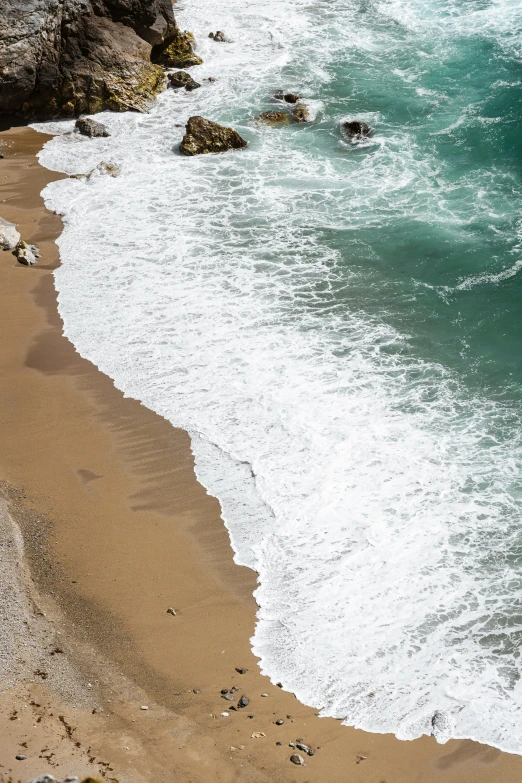 the surf is crashing on the shoreline on the beach