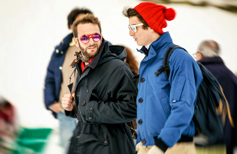 two men walk while dressed up in coats and scarfs