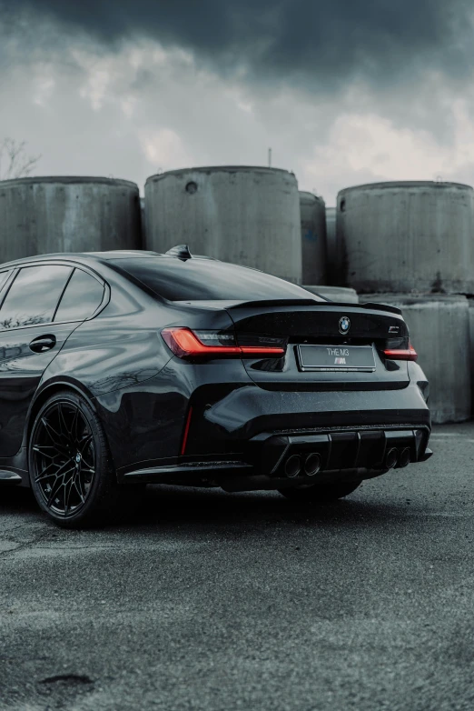 a bmw car sitting in front of a pile of barrels