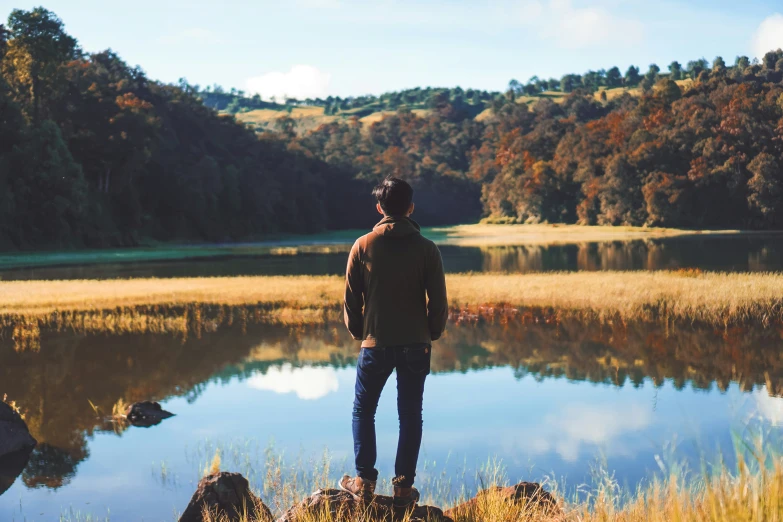 a man in a leather jacket looking out to the water