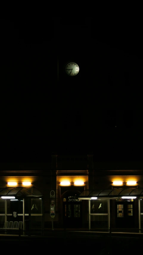 a large clock on top of a building lit up in the dark