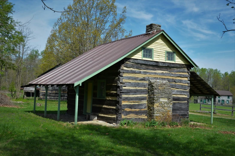 an old log cabin sits in a field