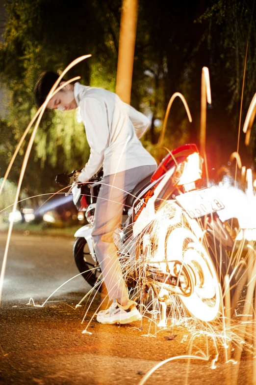 a man is fixing a motorcycle by the road