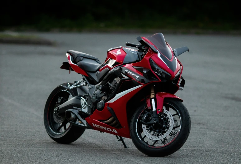 a red motorcycle is parked in a parking lot