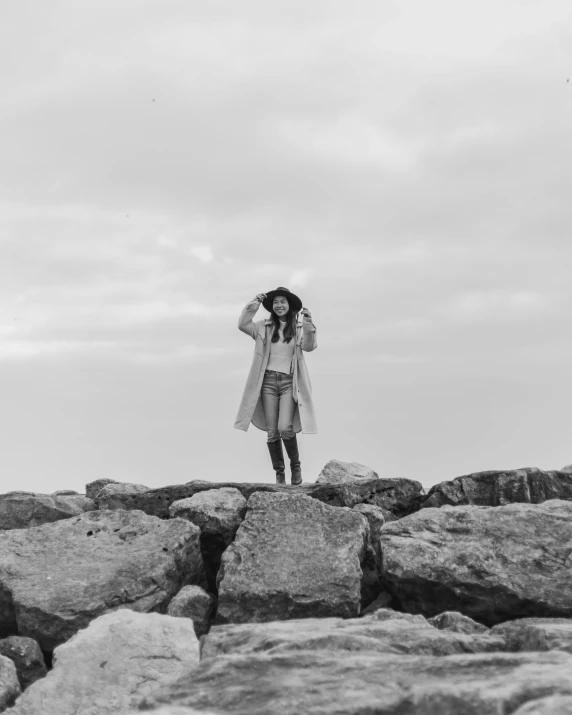 a woman on top of rocks with an umbrella