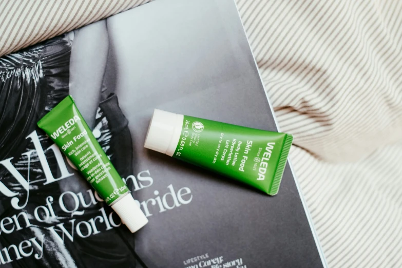 two bottles of eye cream sit on top of a book