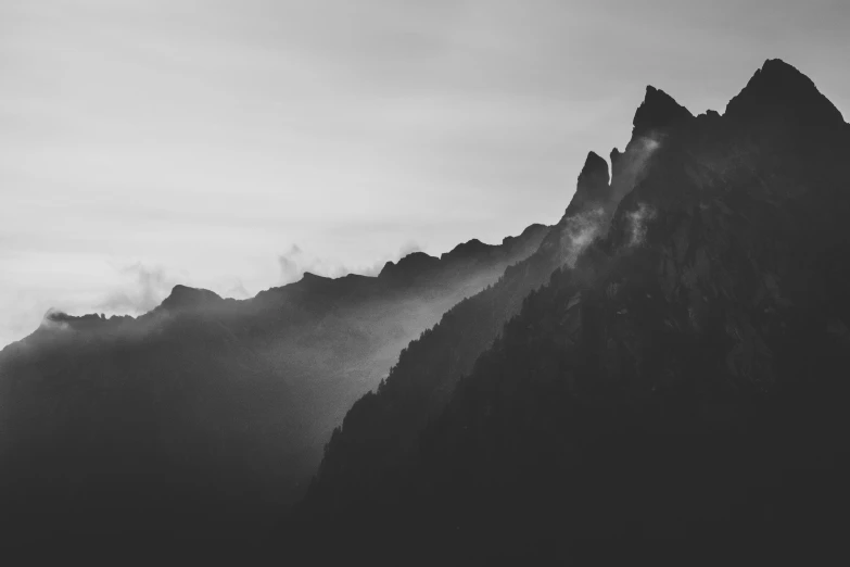 the silhouette of mountains against a cloudy sky