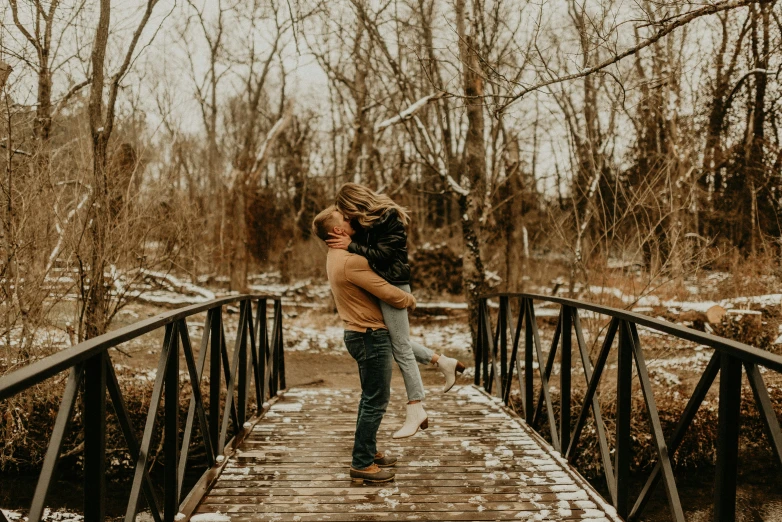 a man is carrying his girlfriend across a bridge