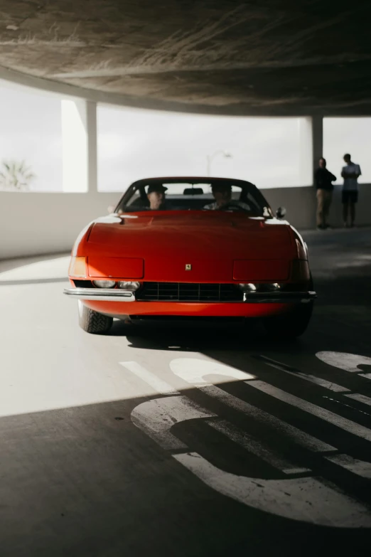 a classic sports car drives down the street