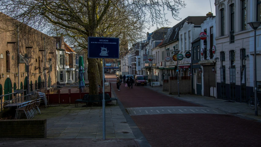 an alley with old buildings and a blue sign