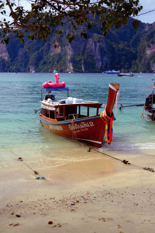 a boat is sitting in the shallow water at a beach