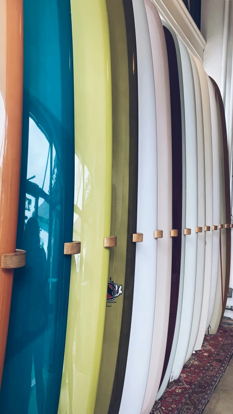 a row of surfboards lined up against a wall