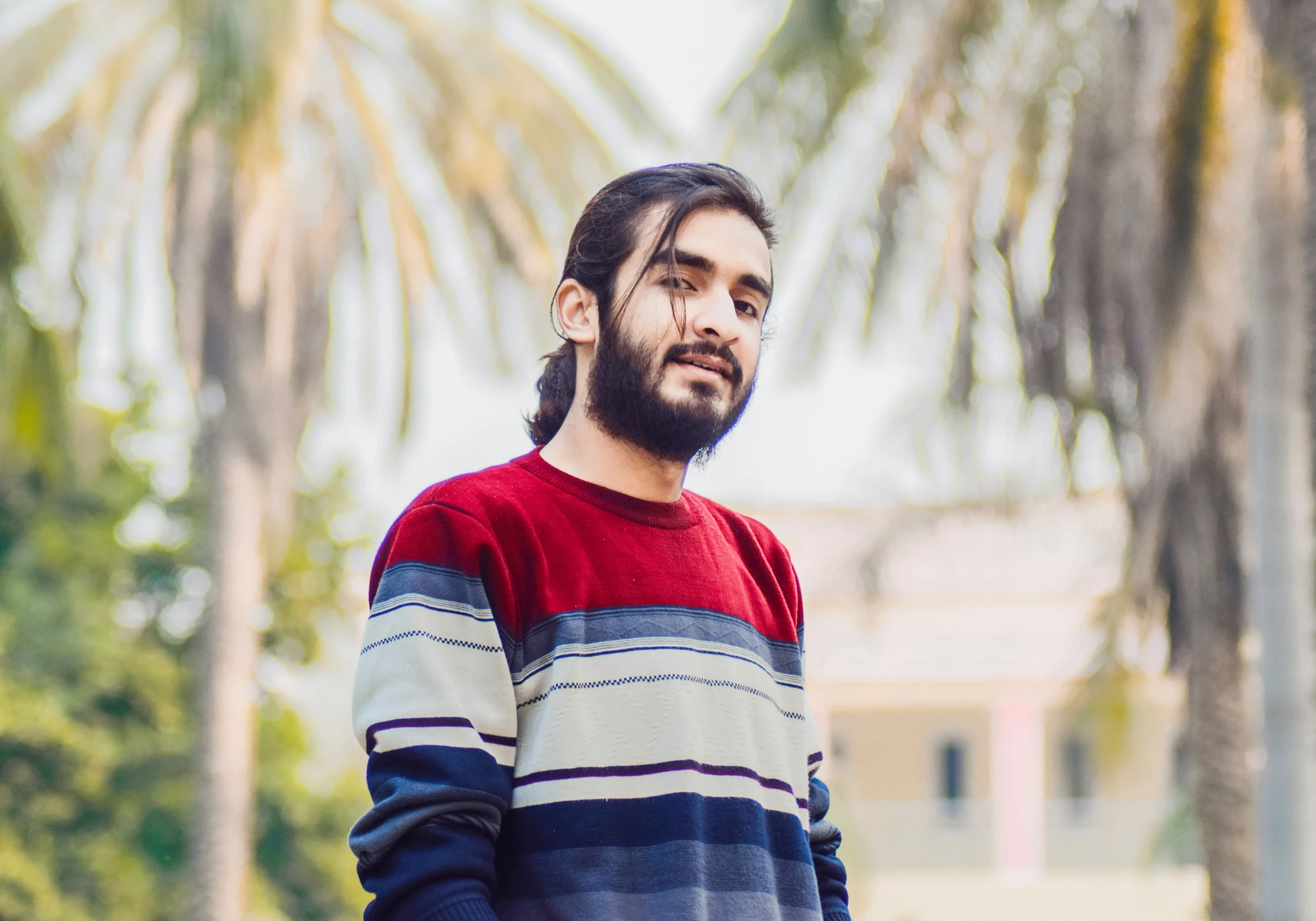 a man in a striped sweater looking off into the distance