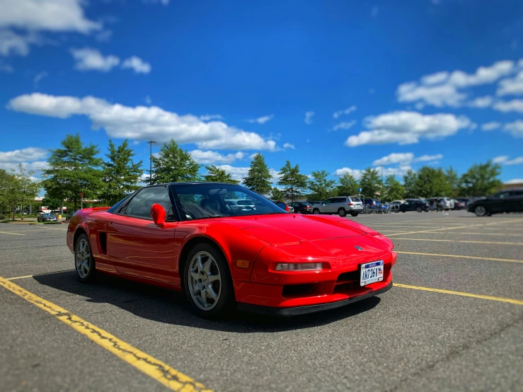 an image of a red convertible car that is in the parking lot