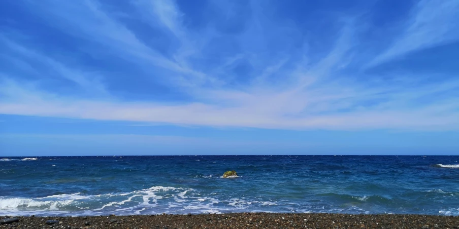 an ocean with waves, rocks and surfboard on top of it