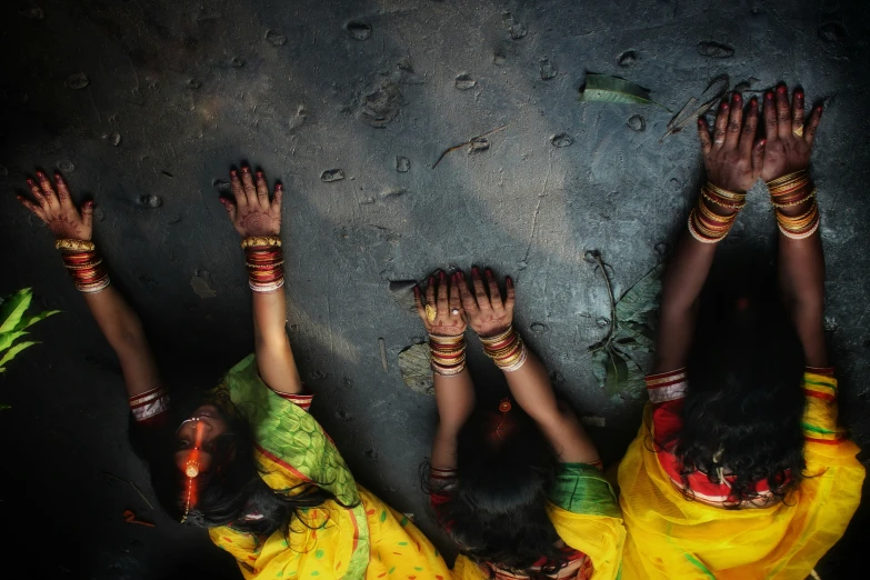 three women wearing bangies are posing for the camera