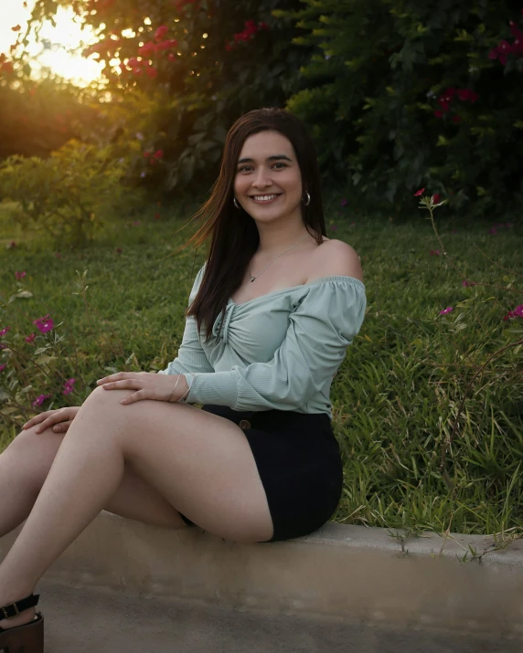 a woman is sitting on the cement posing