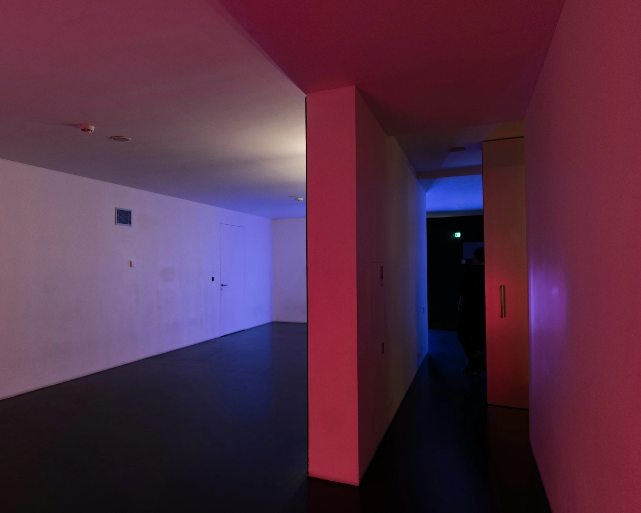 an empty room has a neon colored wall on the right