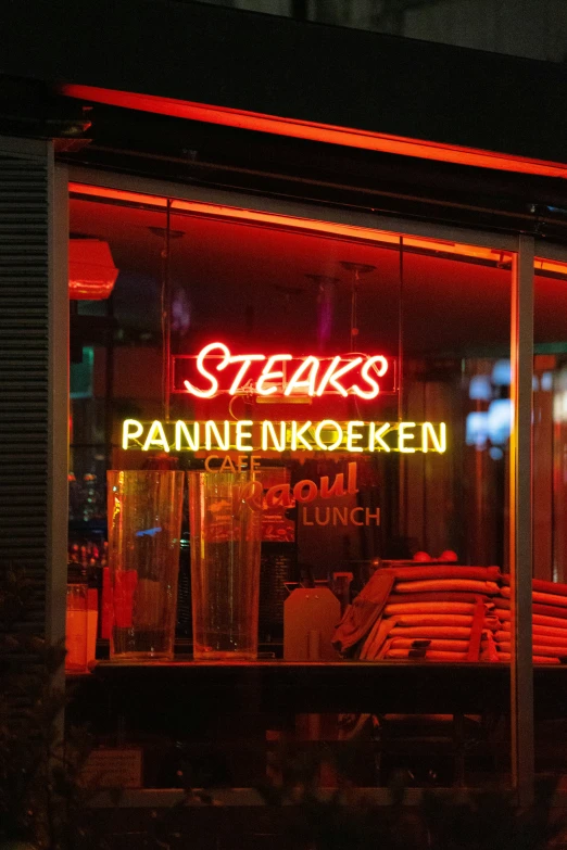 store front at night with lit up sign and furniture