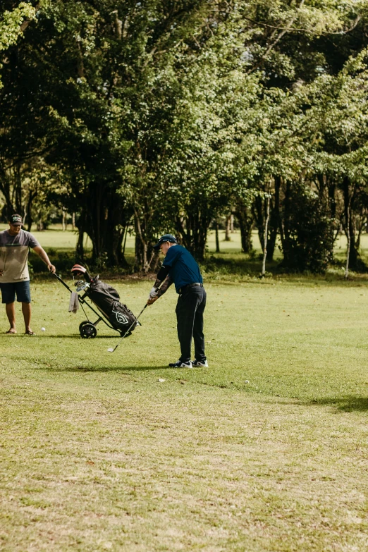 two people standing in a field with a golf bag