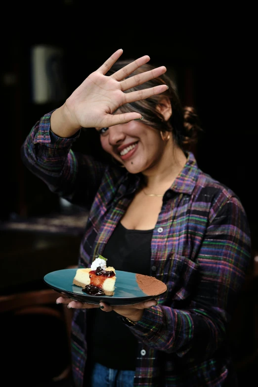 a woman is covering her eyes and has a small piece of cake on a plate