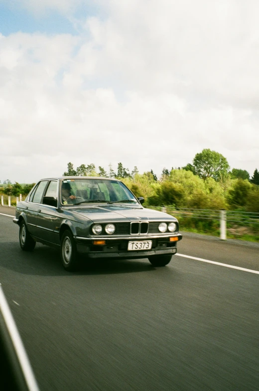 a black car driving down a country road