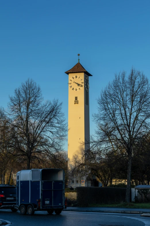 a building has a tower with a clock and a trailer