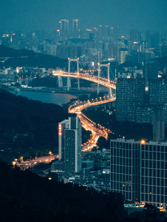 many cars and lights driving down a road over the city