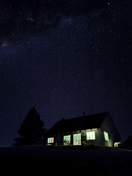 an house lit up at night under the stars