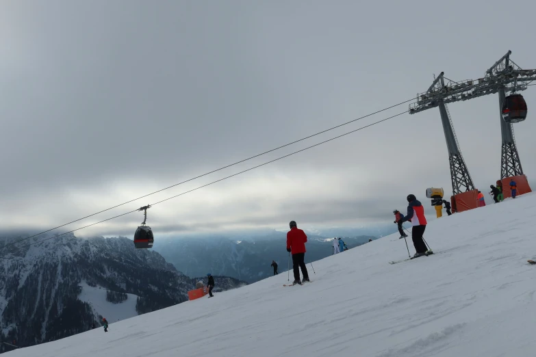 a group of people riding on top of snow covered slope